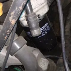 Filtr oleju BOSCH p0011 w silniku, otoczony przewodami i elementami mechanicznymi.