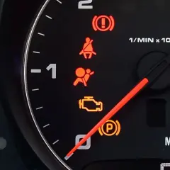 Kontrolka SRS airbag świeci się, sygnalizując problem z poduszkami powietrznymi. Obok widać kontrolki hamulca, pasów, silnika i skrzyni biegów.