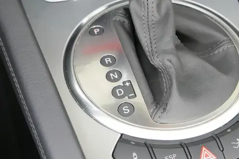 Zbliżenie na panel z oznaczeniami automatycznej skrzyni biegów: P, R, N, D (z możliwością ręcznej zmiany biegów +/–) oraz S.