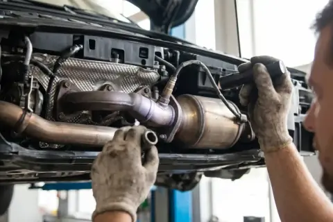 Mechanik naprawia katalizator, który może być przyczyną błędu DTC P0420.