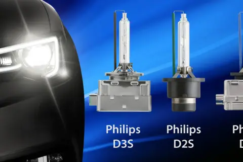 Reflektor samochodu z włączonym światłem ksenonowym obok żarówek Philips D3S, D2S i D8S.