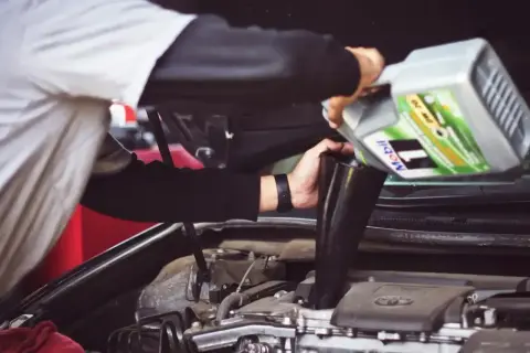 Mechanik wylewa olej silnikowy Mobil 1 do silnika. Pytanie: czy można mieszać oleje silnikowe?