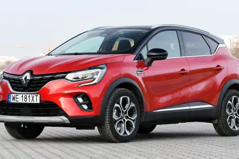 Czerwony Renault Captur na tle miejskiego krajobrazu. Zastanawiasz się, renault captur jaki silnik wybrać?