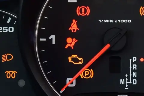 Kontrolka SRS airbag świeci się, sygnalizując problem z poduszkami powietrznymi. Obok widać kontrolki hamulca, pasów, silnika i skrzyni biegów.