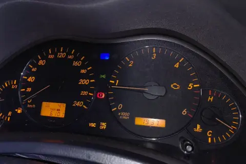 Kontrolka silnika świeci się, wskazując błąd DTC C1201 Toyota. Na desce rozdzielczej widoczne są też inne kontrolki i wskaźniki.