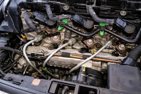 Silnik Peugeot z widocznymi wtryskiwaczami i przewodami paliwowymi. Może to być związane z błędem dtc p1352.
