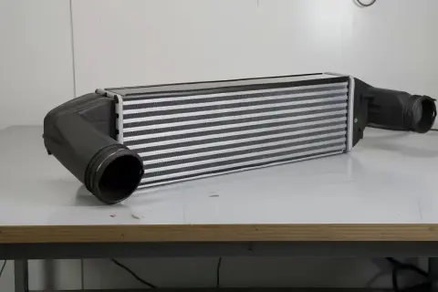 Kuler samochodowy z aluminiowymi żeberkami i czarnymi wlotami.