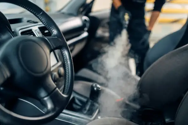 Ozonowanie samochodu: para wydobywa się z urządzenia, odświeżając wnętrze pojazdu. Samodzielne ozonowanie to sposób na czyste i pachnące auto.